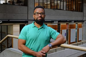 Photo of former CM student Charleston Burr standing in Gould Hall