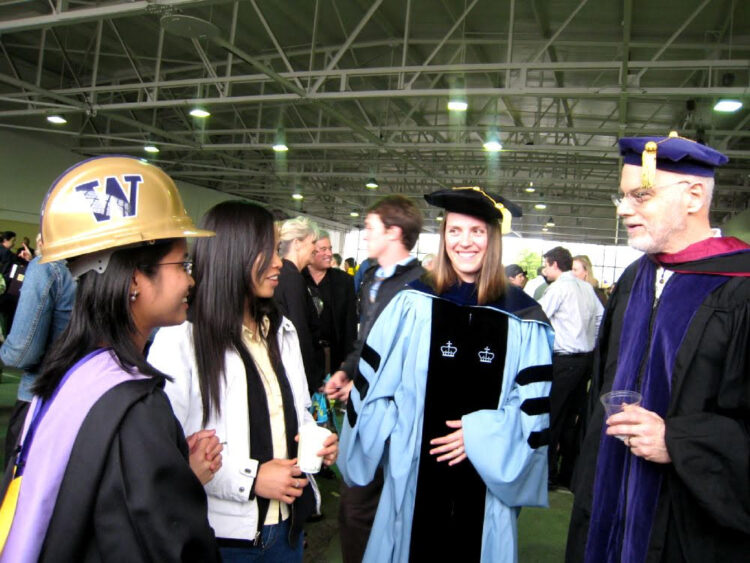 Professors Carrie Sturts Dossick and Steve Goldblatt speaking with a group of female graduate students at 2008 graduation ceremony.