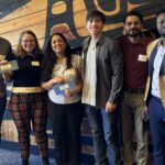 CMAA scholarship recipients standing against a patterned wall