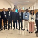 CM faculty and graduate students posing in hallway